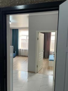 Una puerta que conduce a una habitación con sala de estar. en Royal House, en Almaty