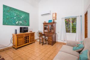 sala de estar con sofá, mesa y TV en Casa Luna, en Tamarindo