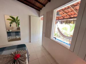 um quarto com uma janela e uma cadeira num quarto em Pousada Nascente do Sol na Ilha de Boipeba