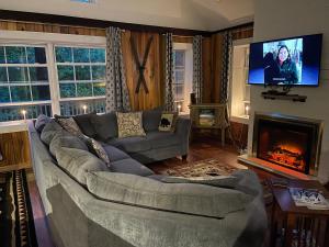 - un salon avec un canapé et une cheminée dans l'établissement Dogwood Mountain House, à Fancy Gap