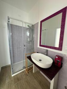 een witte badkamer met een wastafel en een douche bij Molo '93 - RoomsAndSea in Belvedere Marittimo