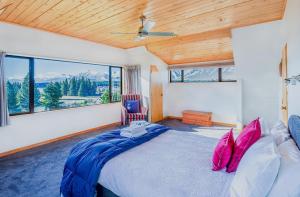 a bedroom with a large bed and a large window at Lake House - Lake Tekapo in Lake Tekapo