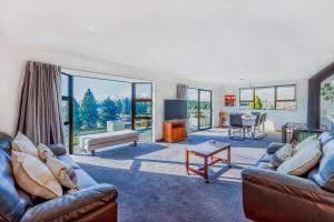 a living room with two couches and a tv at Lake House - Lake Tekapo in Lake Tekapo