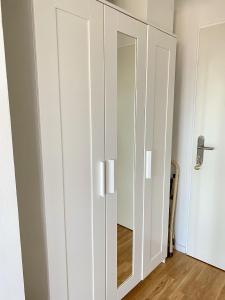 a white cupboard with a mirror in a room at Living in a penthouse in Frankfurt, with balcony for smokers in Frankfurt/Main