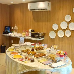 a table with a bunch of food on it at Yolo Hostel in João Pessoa