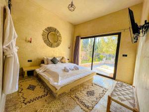 a bedroom with a large bed and a large window at Villa OutMama charme & comfort in Essaouira