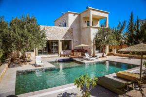 a swimming pool in front of a house at Villa OutMama charme & comfort in Essaouira