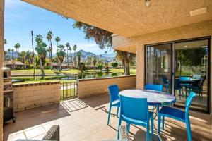 d'une terrasse avec une table et des chaises et une vue sur un parcours de golf. dans l'établissement Sleek Modern Oasis - A Ryson Property, à Palm Springs