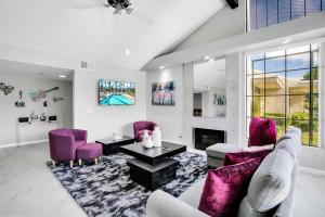 Elle comprend un salon doté d'un mobilier violet et d'une cheminée. dans l'établissement Sleek Modern Oasis - A Ryson Property, à Palm Springs