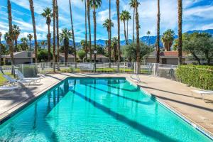 - une piscine avec des palmiers dans un complexe dans l'établissement Sleek Modern Oasis - A Ryson Property, à Palm Springs