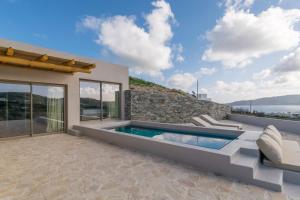 een huis met een zwembad en een patio bij Solus Suites Milos in Adamas