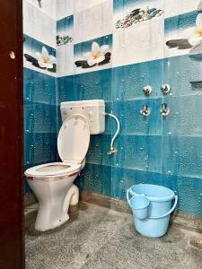 a bathroom with a toilet and two buckets at Cozy 2bhk near Manipal Hospital Dwarka in New Delhi