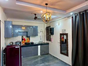 a kitchen with blue cabinets and a ceiling at Cozy 2bhk near Manipal Hospital Dwarka in New Delhi