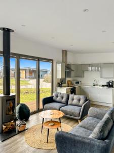 a living room with two couches and a table at "Brett" Scandinavian Lodge with private hot tub in East Bergholt