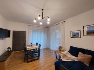 een woonkamer met een tafel en een blauwe bank bij Apartamenty Brenna Klimorówka in Brenna