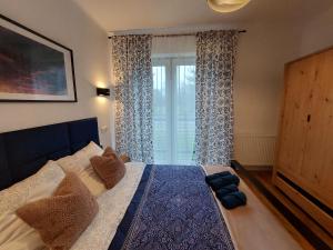 een slaapkamer met een groot bed en een raam bij Apartamenty Brenna Klimorówka in Brenna