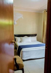 um quarto com uma cama com lençóis azuis e almofadas brancas em NYUMBANI CITY CENTER ACCOMODATION em Kigali