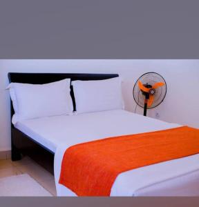 吉佳利的住宿－NYUMBANI CITY CENTER ACCOMODATION，卧室配有白色的床和风扇