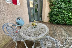 un tavolo in vetro e 2 sedie su un patio di Maison de ville avec jardin proche de Bordeaux a Le Bouscat