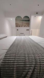 a bed with a black and white striped blanket at 3 Bedroom, 3 Bathroom, Modern Apartment, Leicester in Leicester