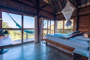 a bedroom with a bed in a room with windows at Paraiso Ahimsa in Buritaca