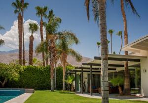uma casa com palmeiras e uma piscina em Lost Oasis - A Ryson Property em Palm Springs
