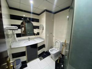 uma casa de banho com um lavatório e um WC em فندق البيت السعيد em Diyā al Kawm