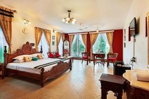 a bedroom with a large bed and a dining room at INDeco Lake Forest in Yercaud