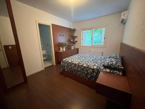 a small bedroom with a bed and a window at Aconchego do centro! in Gramado