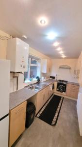 cocina con fregadero y fogones en Three Bed House with free on-site parking Sleeps 5 en Warrington