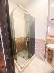 a shower with a glass door in a bathroom at Hotel Villa in Tbilisi City