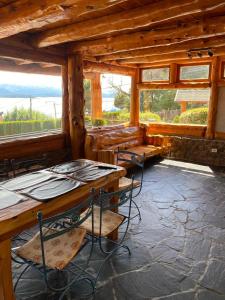 una stanza con tavoli e sedie in una cabina di Le Château a San Carlos de Bariloche