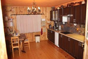 uma cozinha com armários de madeira, uma mesa e uma sala de jantar em Roubenka U Myšáka Jizerské hory em Tanvald