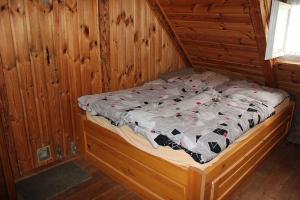 uma cama num quarto com uma parede de madeira em Roubenka U Myšáka Jizerské hory em Tanvald