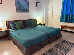a bedroom with a large bed with green pillows at Bacolet Beach House- 5 Bedrooms/ 5 Bathrooms in Bacolet