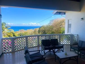 Un balcón con sillas y vistas al océano. en Bacolet Beach House- 5 Bedrooms/ 5 Bathrooms en Bacolet