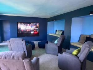sala de estar con sillas y TV de pantalla plana en Bacolet Beach House- 5 Bedrooms/ 5 Bathrooms en Bacolet