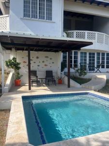 a swimming pool in front of a house at Bacolet Beach House- 5 Bedrooms/ 5 Bathrooms in Bacolet