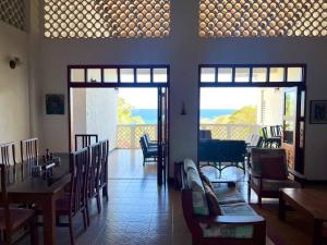 a dining room with tables and chairs and a view of the ocean at Bacolet Beach House- 5 Bedrooms/ 5 Bathrooms in Bacolet