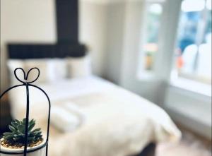 a glass vase with a plant on a table in a bedroom at Charming En-Suite in London in London