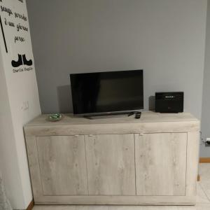 uma televisão de ecrã plano em cima de um armário de madeira em House IL CORALLO em Castrezatto