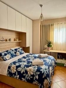 um quarto com uma cama com um cobertor azul e branco em SkyView Oasis Premium Apartment em Tirana