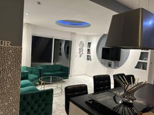 una sala de estar con muebles verdes y un frisbee azul en Maison entière en Cébazat