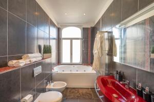 a bathroom with a red sink and a bath tub at Euro Edens Brussels - Family Home & Free Gym Access in Brussels +52 photos