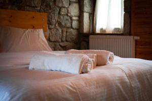 a bedroom with a bed with towels on it at Voskopoje in Korçë