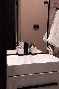 ein Badezimmer mit einem weißen Waschbecken und einem Spiegel in der Unterkunft Дом с потрясающим видом in Almaty