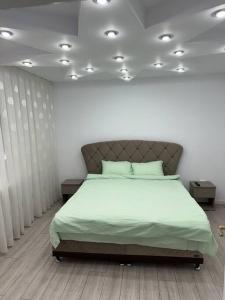 a bedroom with a large bed with green sheets at Casă de închiriat în regim hotelier lângă Nimphaea in Oradea