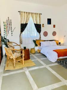 een slaapkamer met een bed, een stoel en een raam bij Lions house arusha Airbnb in Arusha