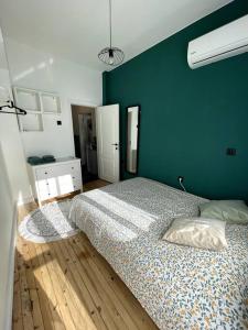 ein Schlafzimmer mit einem großen Bett und einer grünen Wand in der Unterkunft Green Flat Sofia Historic Center in Sofia