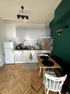 eine Küche mit einem Holztisch und einem weißen Kühlschrank in der Unterkunft Green Flat Sofia Historic Center in Sofia